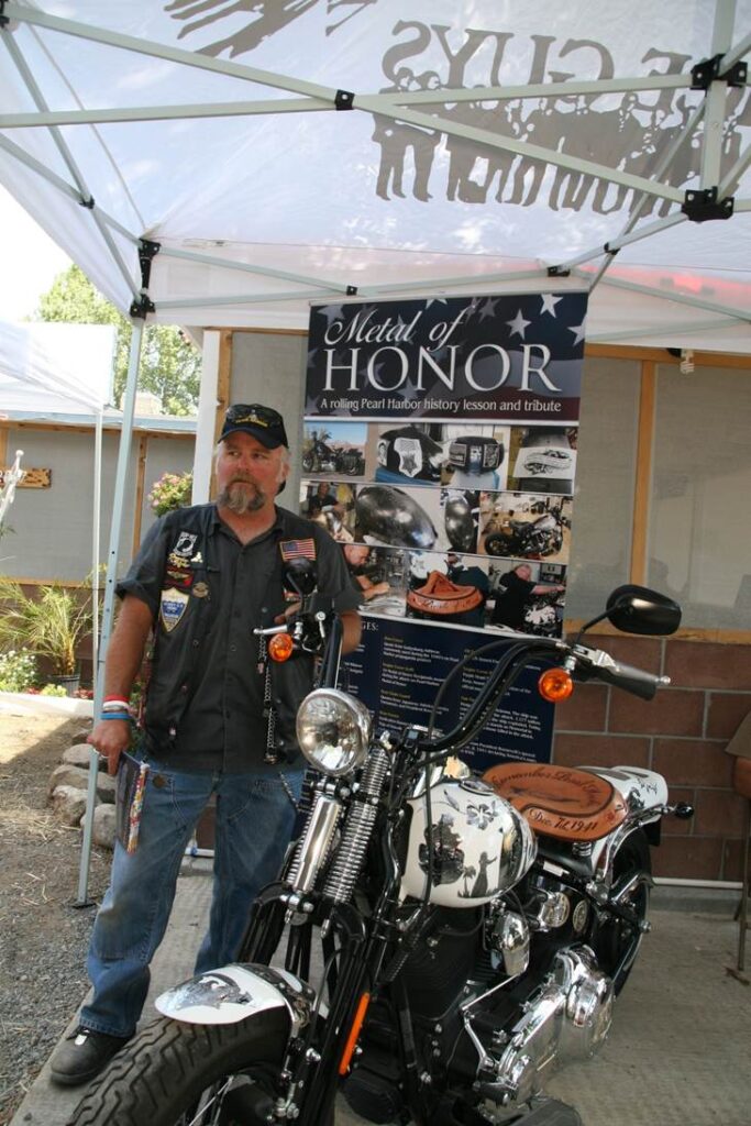 Dana F. Harbaugh, owner and designer of Metal of Honor, with the motorcycle