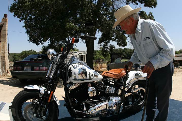 Medal of Honor recipient John Finn examining the engraved Medal of Honor image on the bike’s gas tank