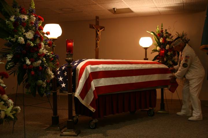 Stu Hedley of the USS West Virginia adjusting the flag draped over John Finn’s casket
