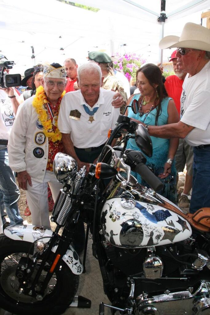 Stu Hedley of the USS West Virginia hugging John Finn beside Metal of Honor